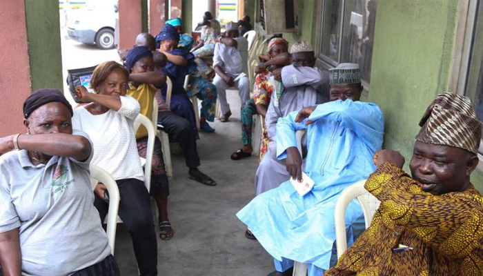 People living in Lagos State in Nigeria, simulate sneezing into their elbows during a coronavirus prevention campaign.
